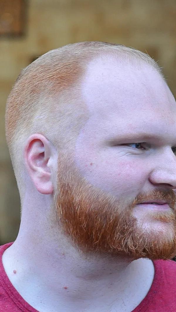Buzz cut kapsel met volle rode baard, profielportret