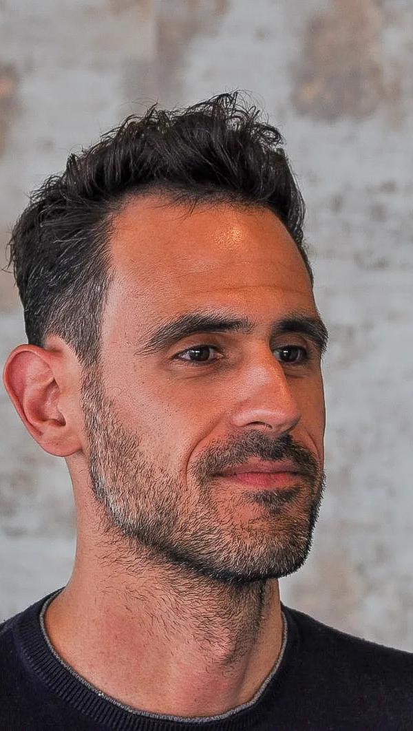 Textured quiff kapsel met stoppelbaard, frontaal portret bij Barber Poort Almere