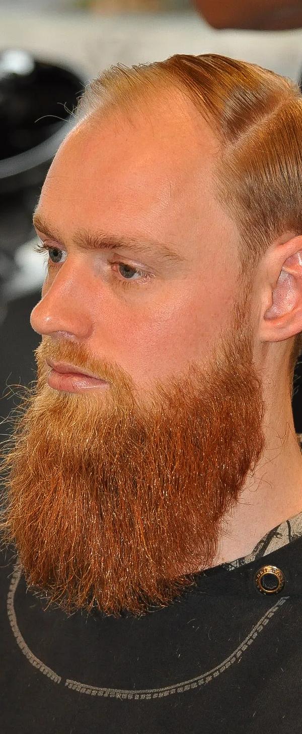Slick back kapsel met volle rode baard en side part