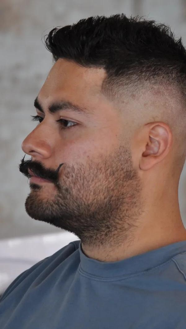 Skin fade kapsel met snor en baard, profielportret