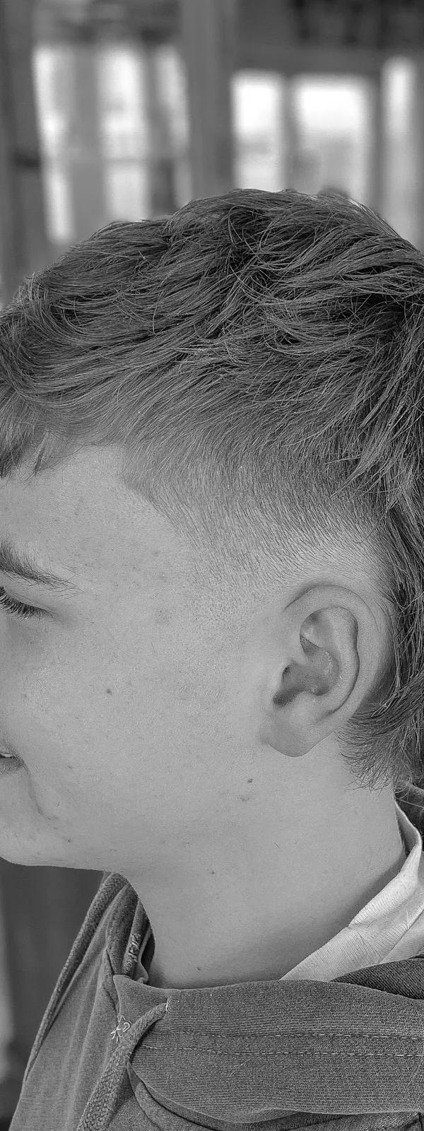Textured crop kapsel met fade, zwart-wit profielportret jongere klant