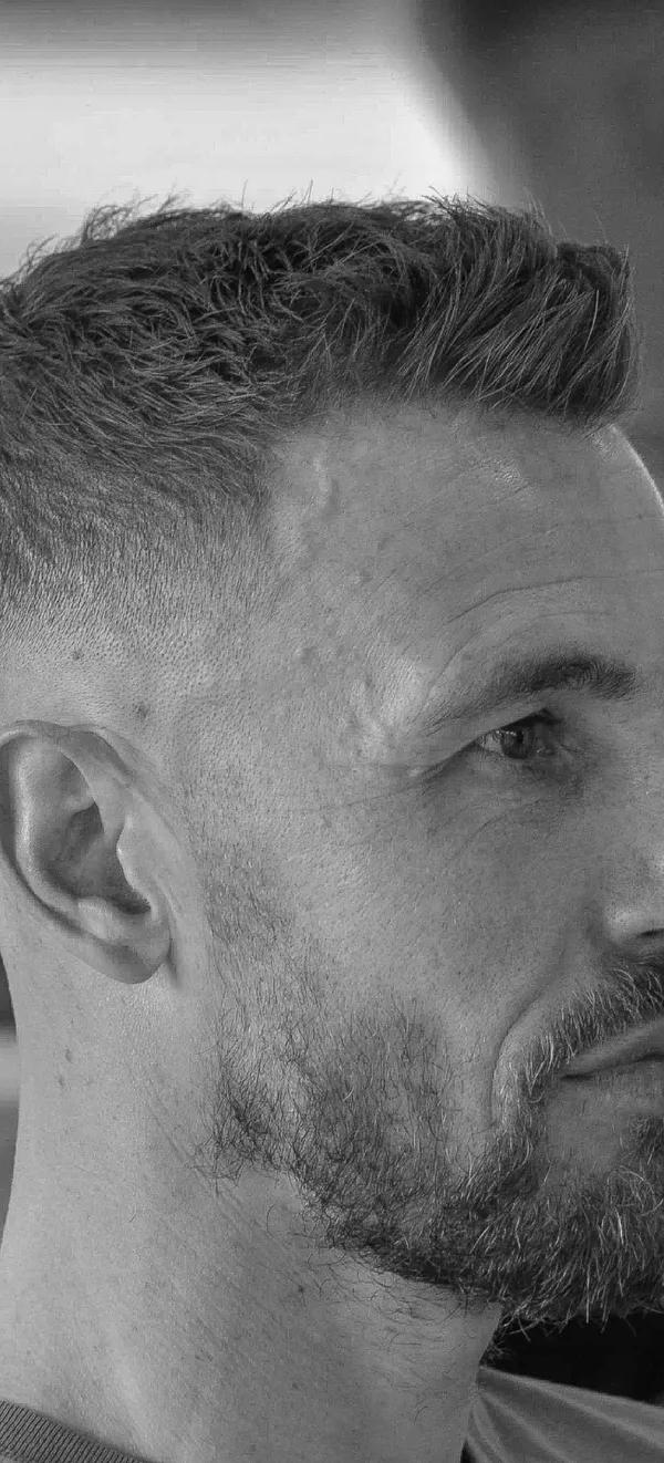 Textured spiky cut met skin fade en baard, zwart-wit profielportret