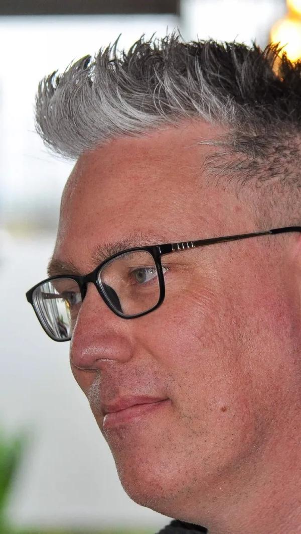 Spiky cut met skin fade, grijs haar en bril, profielportret
