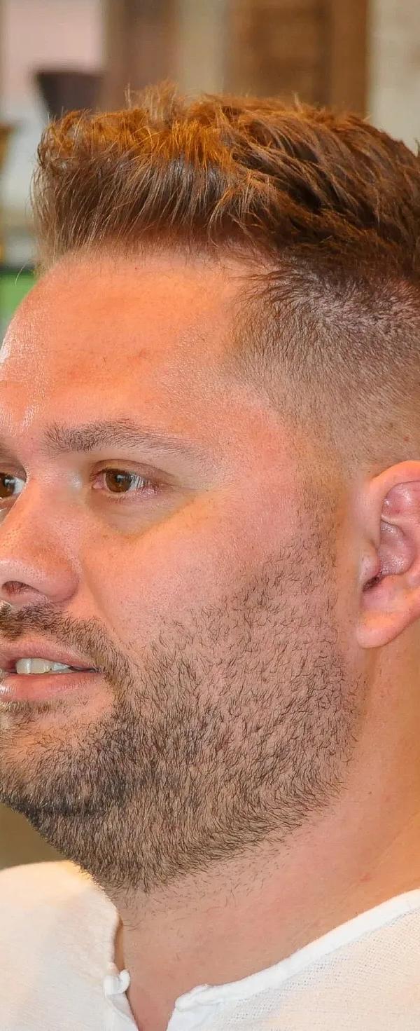 Korte spiky cut met fade en stoppelbaard, profielportret bij Barber Poort Almere
