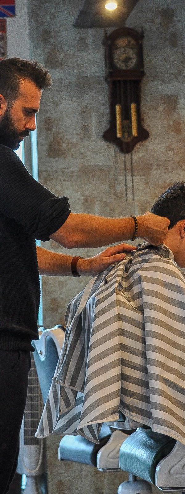 Vakbarber knipt klant in Barber Poort Almere — strakke fade