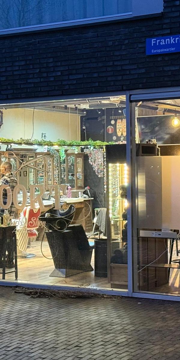 Buitenkant van Barber Poort Almere bij avond met verlichte gevel