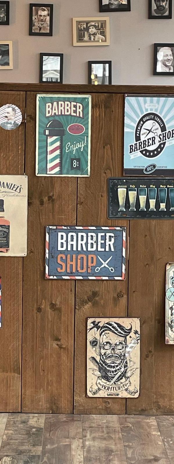 Vintage barbershop signs aan de muur van Barber Poort Almere